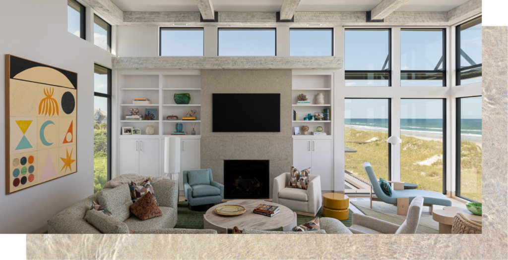 Transitional living space of a Figure 8 Island, NC beach house featuring large windows and eclectic decor.