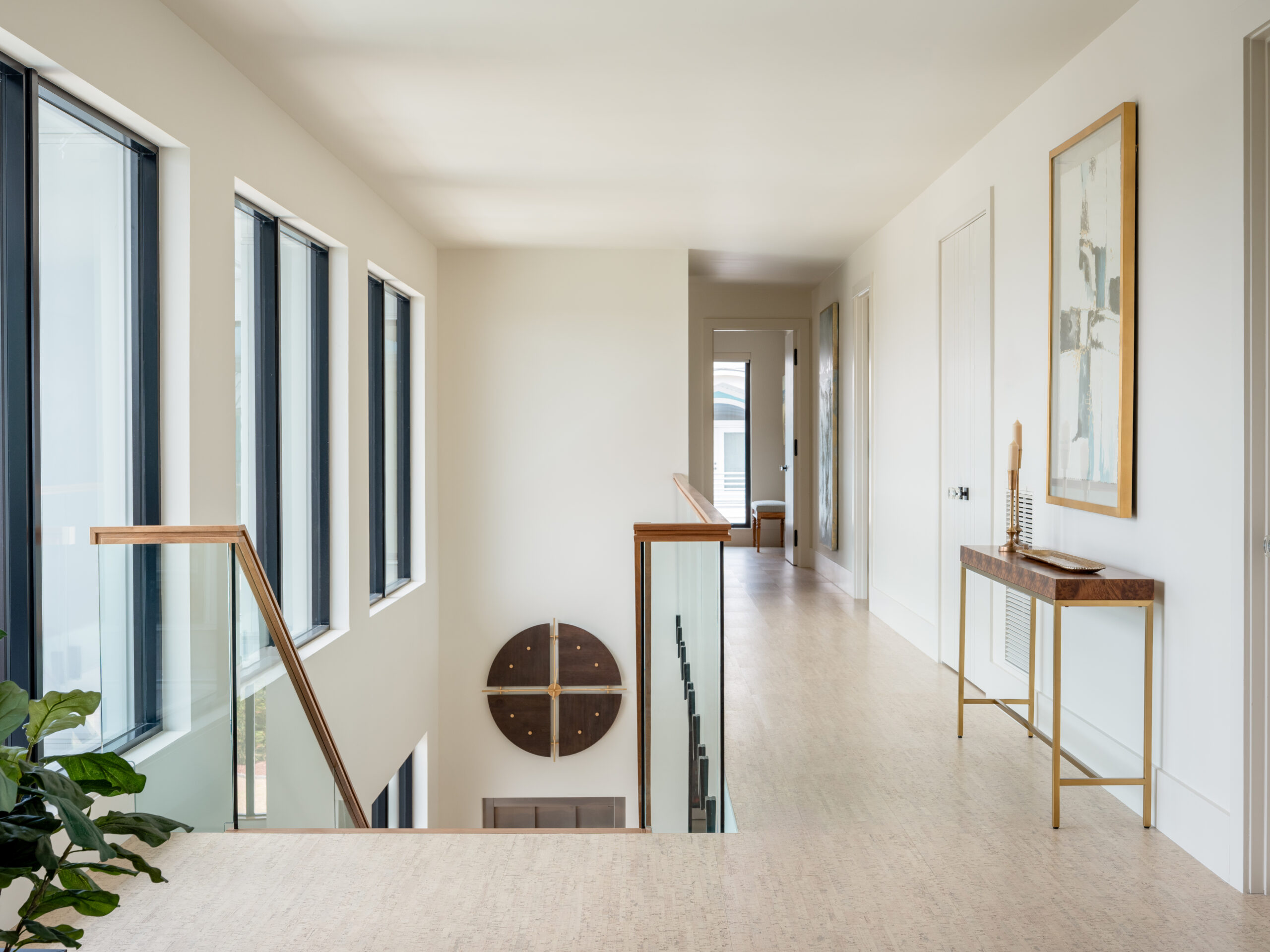 View of the landing of the top of the stairs of a naturally lit modern-transitional home in Carolina Beach, NC designed and built by Tongue and Groove.