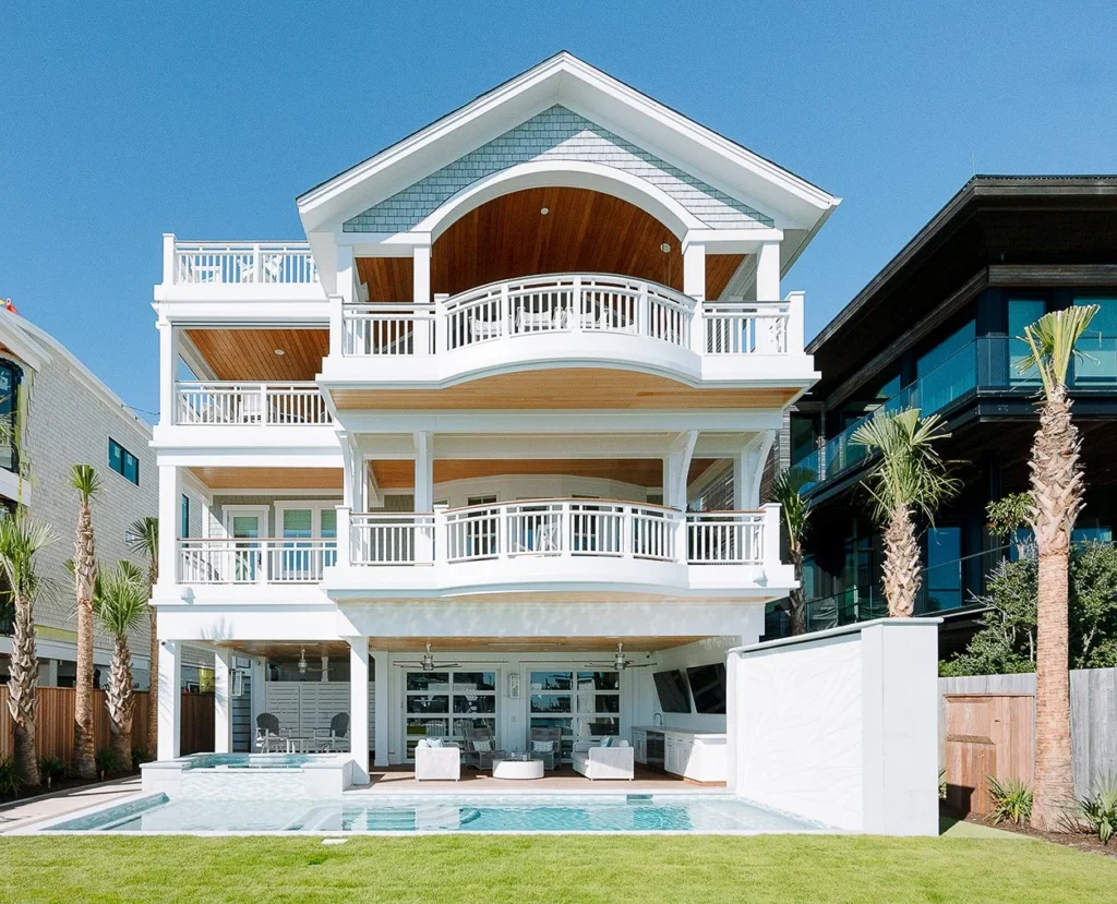 Wrightsville Beach outdoor living renovation featuring a waterfront pool, covered entertaining area, coastal landscaping, and updated exterior architecture.