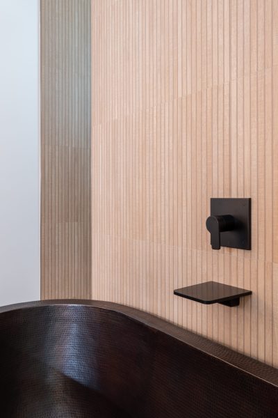 Copper soaking tub in a modern bathroom with beadboard walls