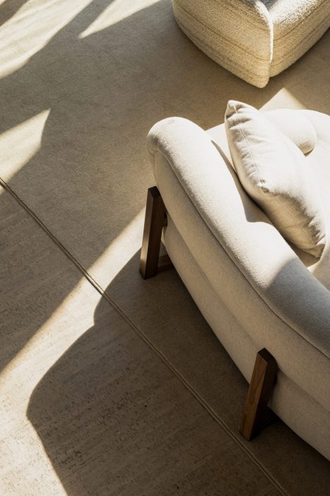 Soft afternoon light hits a sherpa sofa in a minimalistic and neutral living room.